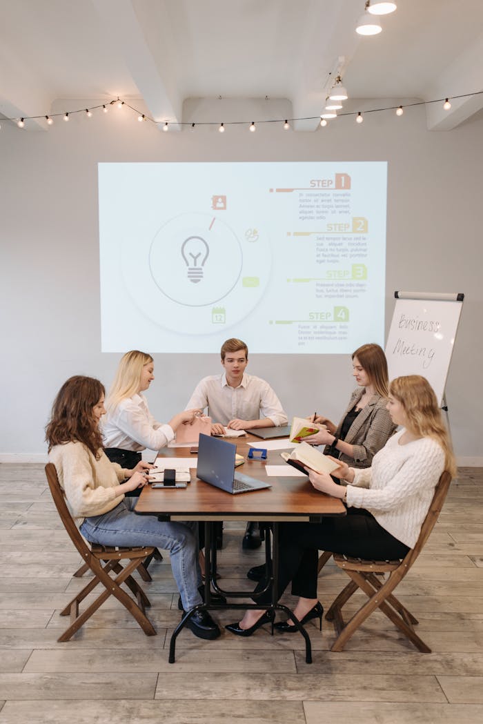 Group of People Sitting on Chair in Front of Table